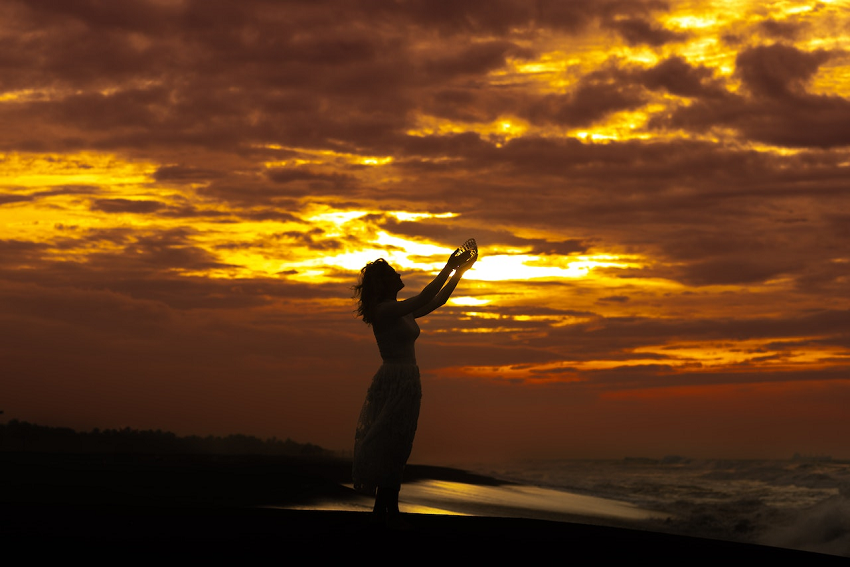 woman with arms reaching to the sky in gratitude