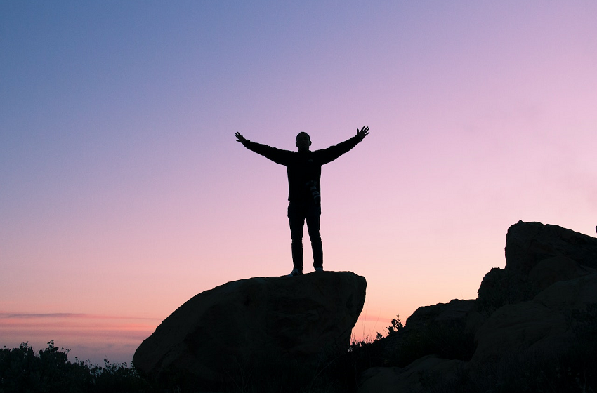 man raising his arms in the air with gratitude