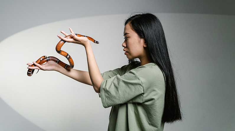 women holding a snake to overcome her fear
