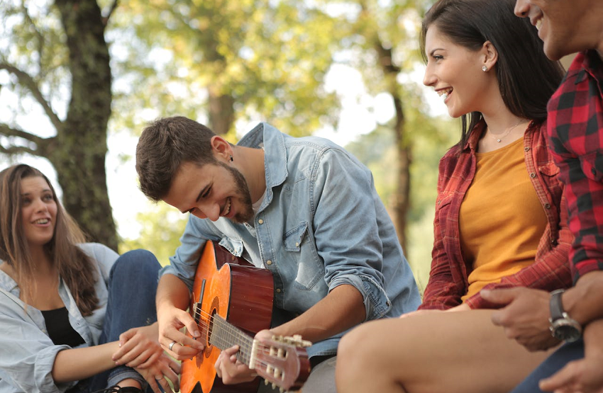 friends enjoying music outside in nature