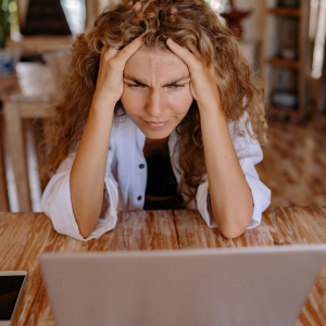 worried woman looking at her laptop