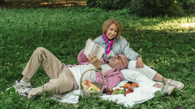 couple relaxing outside reading and having a picnic