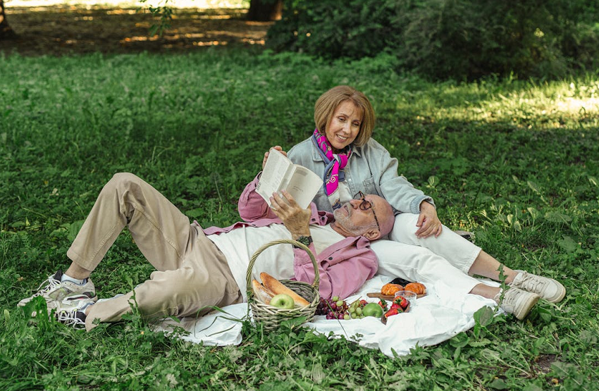 couple relaxing outside reading and having a picnic