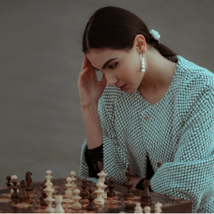 woman playing chess and thinking hard