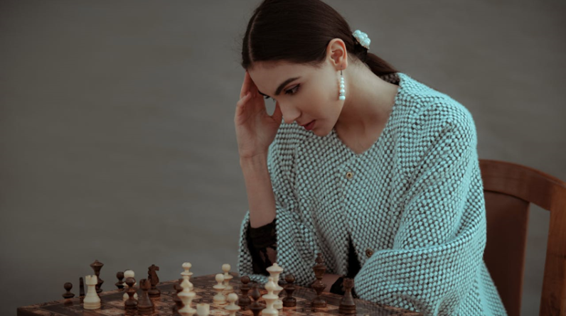 woman playing chess and thinking hard