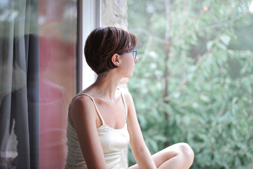 woman relaxing and looking out the window at nature