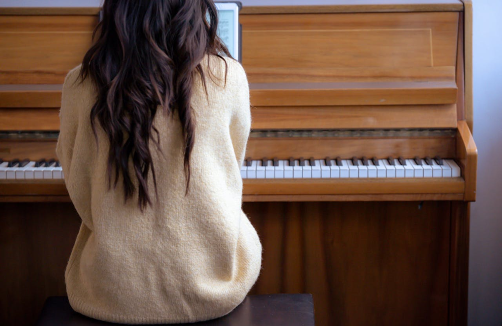 woman learning how to play piano