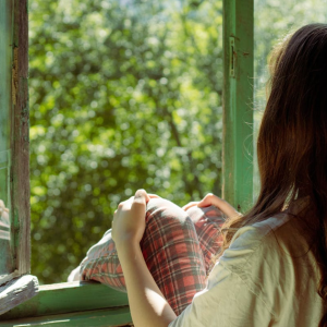 woman sitting beside window