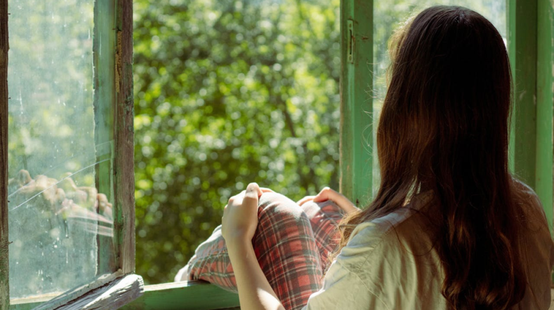 woman sitting beside window