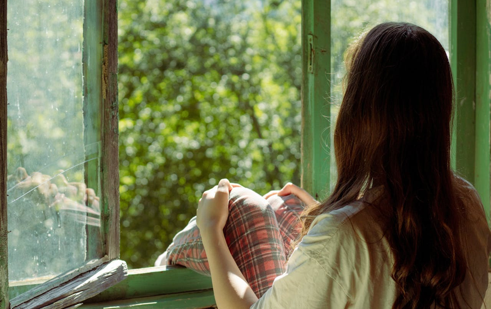 woman sitting beside window